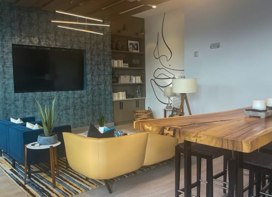 a living room with a tv and a wooden table at Link Apartments® Canvas, Atlanta, 30312
