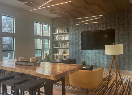 a room with a table and chairs and a flat screen tv on the wall at Link Apartments® Canvas, Atlanta, GA