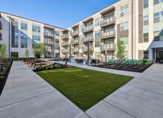 an exterior view of an apartment building with a sidewalk and grass at Link Apartments® Broad Ave, Memphis, 38112