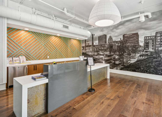 a lobby with a reception desk and a black and white photo of a city skyline at Link Apartments Innovation Quarter, Winston Salem