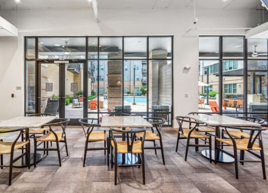 a dining area with tables and chairs and glass doors at Link Apartments Innovation Quarter, North Carolina, 27101