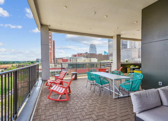 a balcony with a table and chairs and a view of the city at Link Apartments Innovation Quarter, Winston Salem, NC, 27101