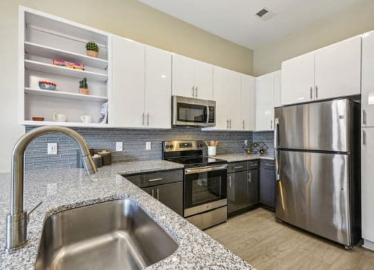 a modern kitchen with stainless steel appliances and granite counter tops at Link Apartments Innovation Quarter, Winston Salem, 27101
