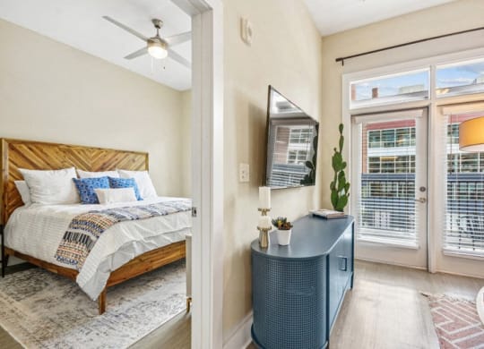 a bedroom with a bed and a door to a balcony at Link Apartments Innovation Quarter, North Carolina, 27101