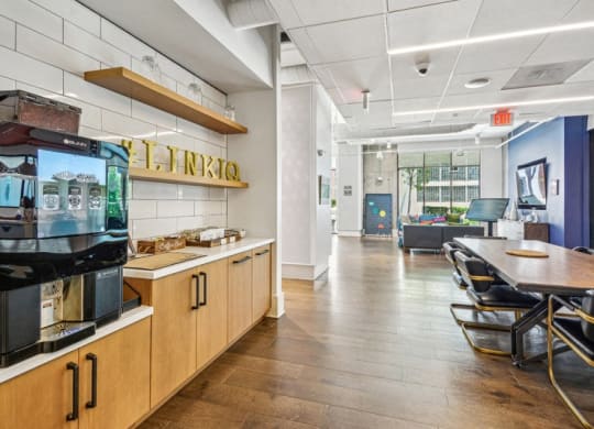 a dining room with a table and chairs and a coffee machine at Link Apartments Innovation Quarter, Winston Salem, 27101