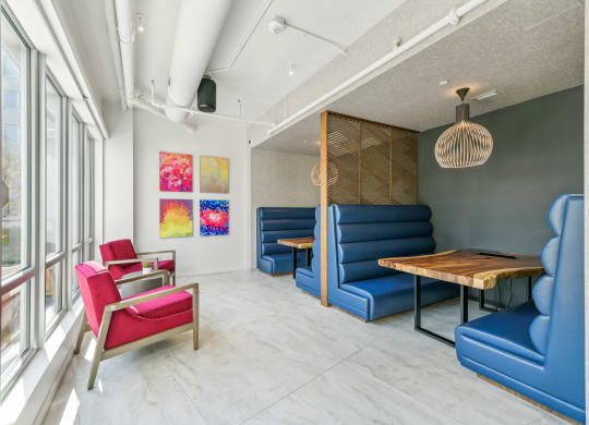 a living room with blue couches and chairs and a wooden table at Link Apartments® H Street, Washington, Washington