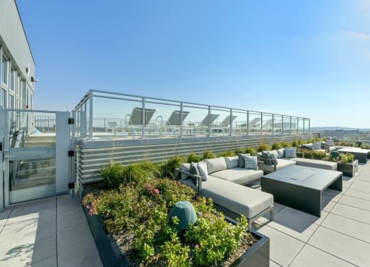 a terrace with couches and tables on a roof top  at Link Apartments® H Street, Washington, DC