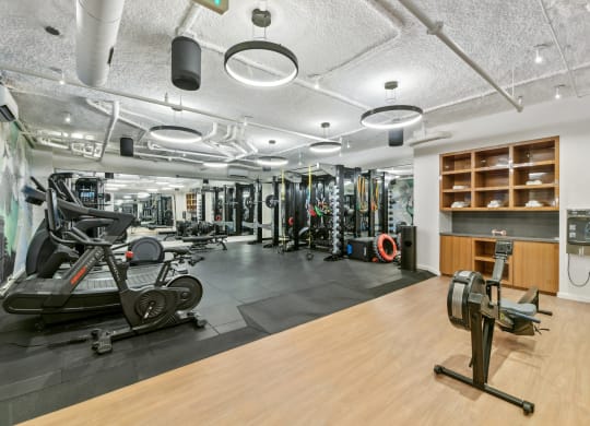 a gym with weights and other exercise equipment on a wooden floor  at Link Apartments® H Street, Washington, Washington