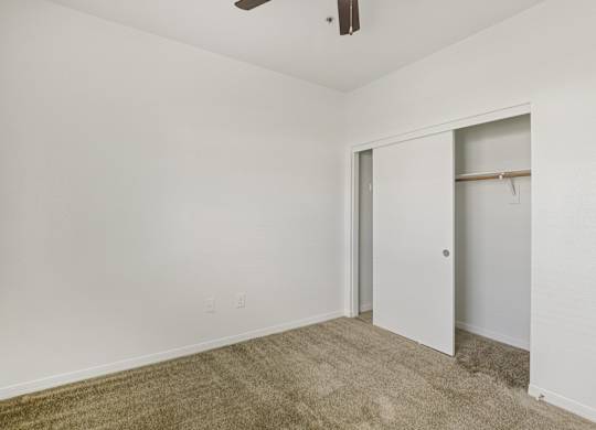 A room with a carpeted floor and a ceiling fan. at Rome Park Villas, Nevada, 89084