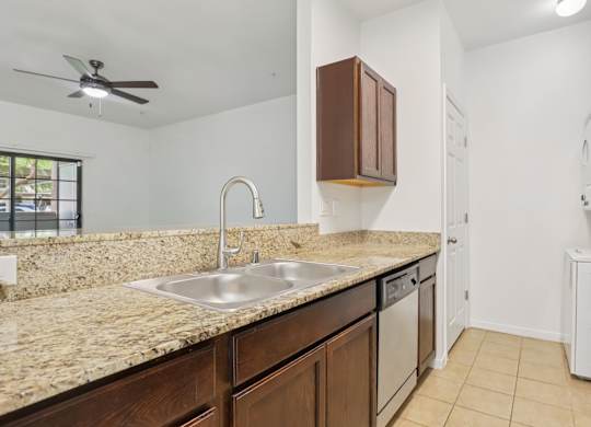A kitchen with a sink, refrigerator, and cabinets. at Rome Park Villas, North Las Vegas, NV