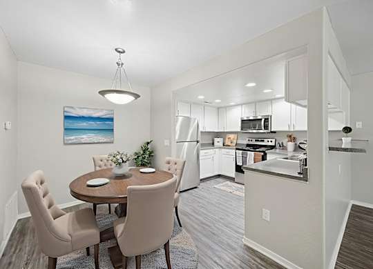 A modern kitchen with a dining table and chairs.