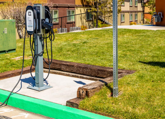 a gas pump sitting next to a street sign in front of some houses