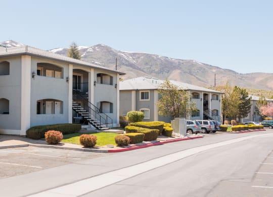 a row of apartment buildings with mountains in the background