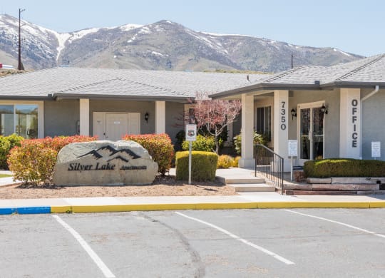 a building with mountains in the background in a parking lot