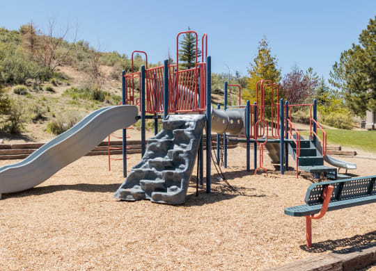 a playground with slides and benches in a park