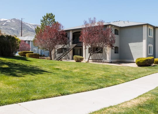 a gray house with a sidewalk in front of it