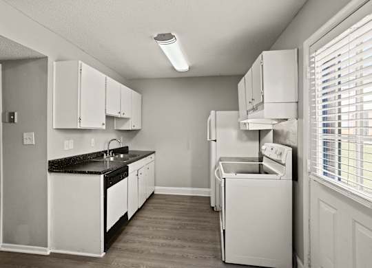 A kitchen with white appliances and cabinets.