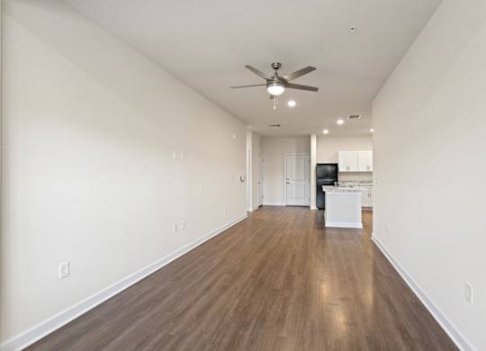 Peaks of Lexington Apartments Kitchen with Black Appliances, Granite Countertops and White Cabinetry and connected living room