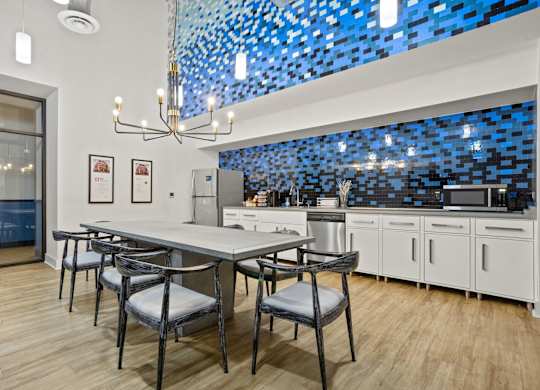 Aug Smith on Main Lounge Kitchen with dining room table and chairs, stainless steel refrigerator, Keurig and K-cups, microwave, dishwasher and sink.