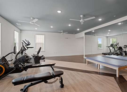 Ovata at Reedy Creek Senior Apartments in Charlotte NC Fitness Center with elliptical, stationary bike, dumbbells, benches, yoga balls, chest press and leg press.