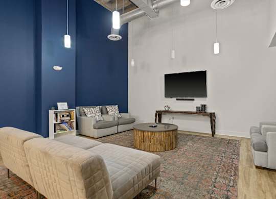 Aug Smith on Main community room, with three couches, a TV and a resident library.