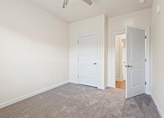 Peaks of Lexington Apartments Bedroom with Ceiling Fan, Light, Window and Gray Carpet