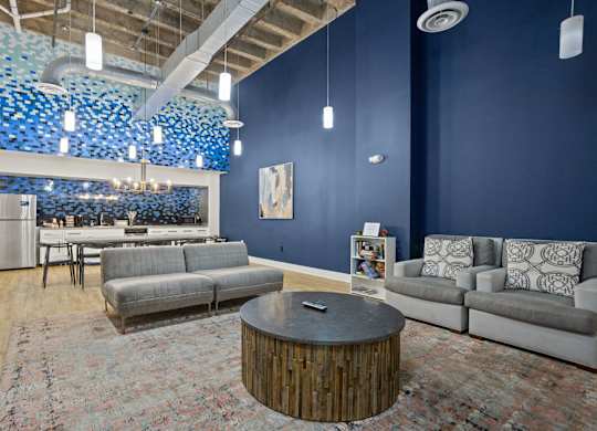 Aug Smith on Main community room, with two couches, a dining room table and a full kitchen with a Keurig.