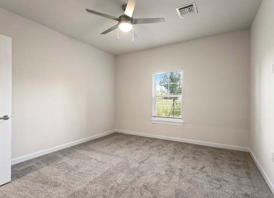 Peaks of Lexington Apartments Bedroom with Ceiling Fan, Light, Window and Gray Carpet and Connected Bathroom