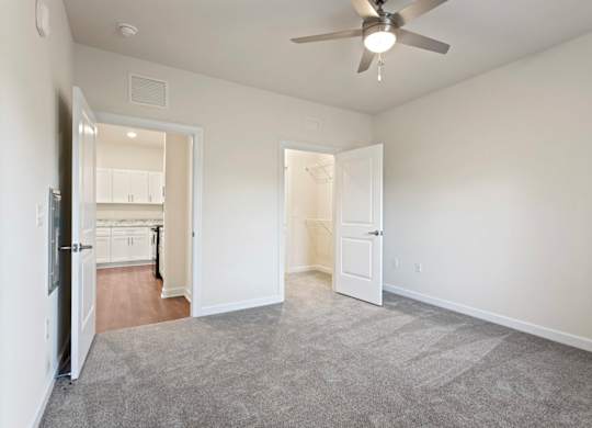 Peaks of Lexington Apartments Kitchen with Black Appliances, Granite Countertops and White Cabinetry, walk-in closet and connected living room
