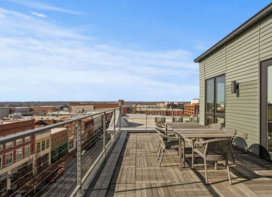 Aug Smith On Main Rooftop Terrace with table and chairs, overlooking Spartanburg