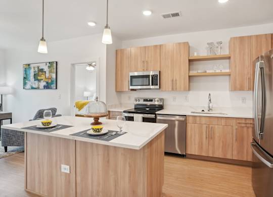 A modern kitchen with wooden cabinets and stainless steel appliances.