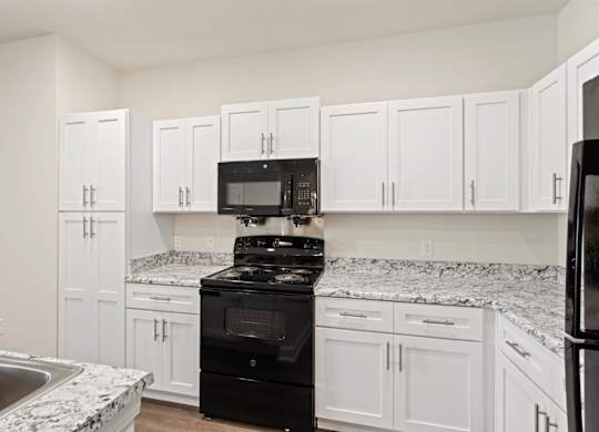Peaks of Lexington Apartments Kitchen with Black Appliances, Granite Countertops and White Cabinetry