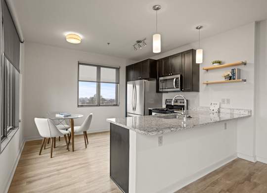 A modern kitchen with a dining table and chairs.