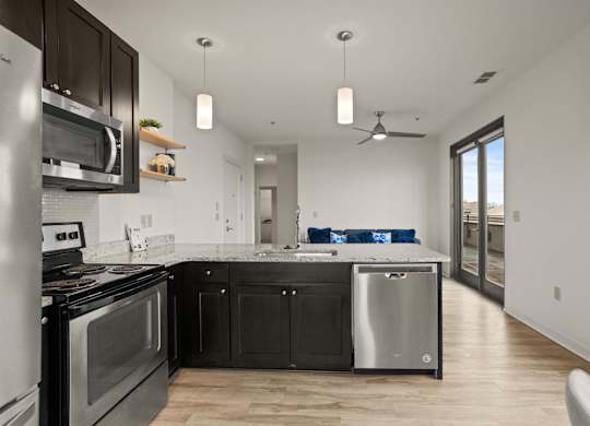 Aug Smith on Main kitchen with island, stainless steel appliances, balconies, and lvt flooring.