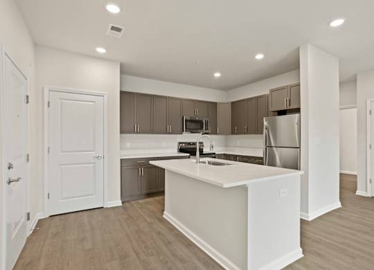 Grande at Geyser Falls Luxury Apartments Open Concept Kitchen with Quartz Countertops, Island and Stainless Steel Appliances