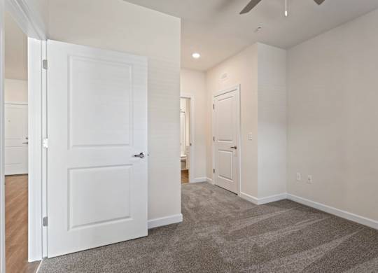 Peaks of Lexington Apartments Bedroom with Ceiling Fan, Light, Window and Gray Carpet and Connected Bathroom