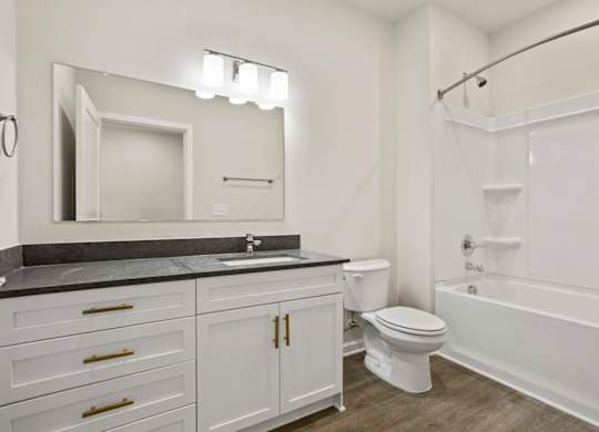 A bathroom with a sink, toilet, and bathtub.
