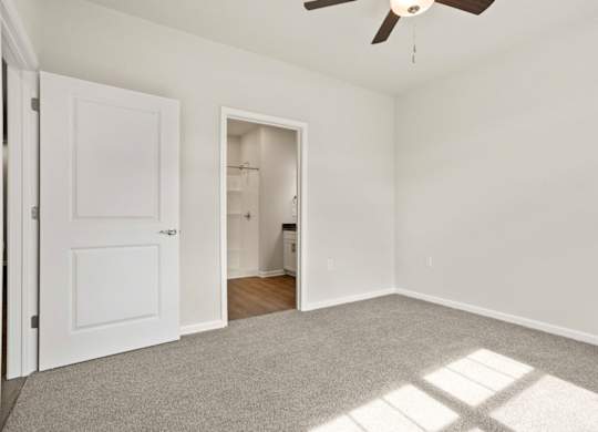 A room with a ceiling fan and a door.