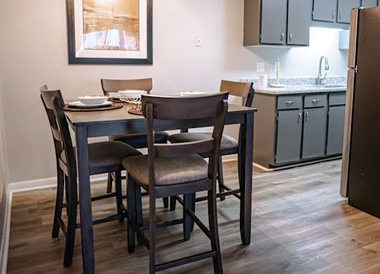 A dining room with a table and chairs and a ceiling fan.