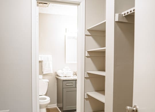 A white bathroom with a toilet, sink, and a white cabinet.