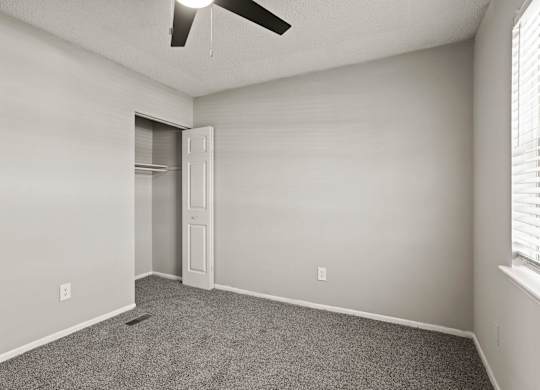 A room with a ceiling fan and a door.