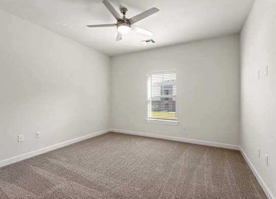Peaks of Lexington Apartments Bedroom with Ceiling Fan, Light, Window and Gray Carpet