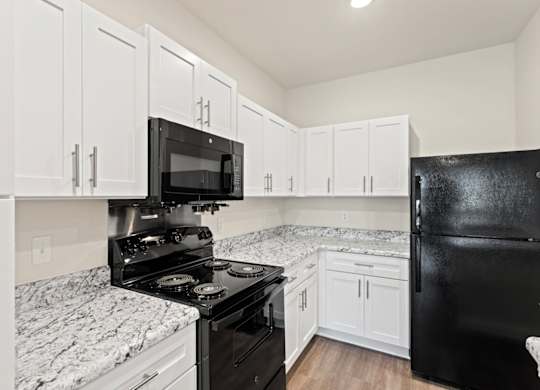 Peaks of Lexington Apartments Kitchen with Black Appliances, Granite Countertops and White Cabinetry