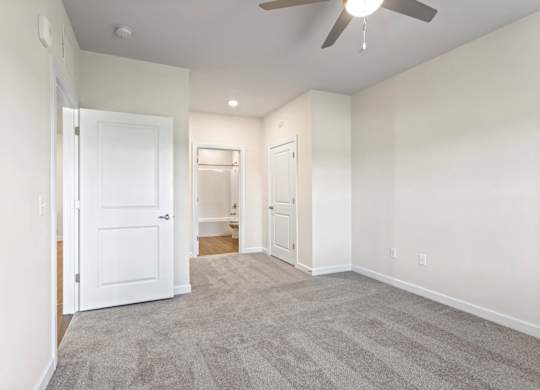 Peaks of Lexington Apartments Bedroom with Ceiling Fan, Light, Window and Gray Carpet and Connected Bathroom