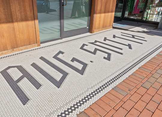 Tiled floor entrance of Aug Smith on Main, reading AUG SMITH.
