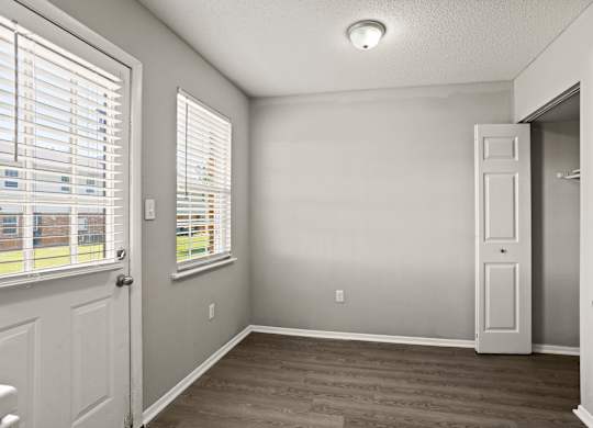 A room with a door, window, and a light on the ceiling.