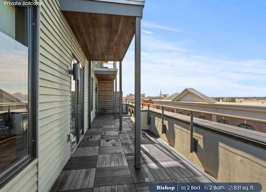 A balcony with a wooden floor and a metal railing.