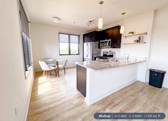 A kitchen with a refrigerator, microwave, and oven.