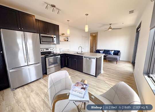 A kitchen with a refrigerator, microwave, oven, and sink.