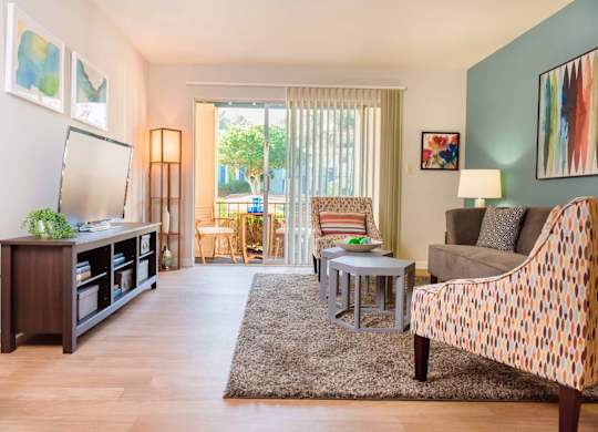 A living room with a couch, chair, and television.